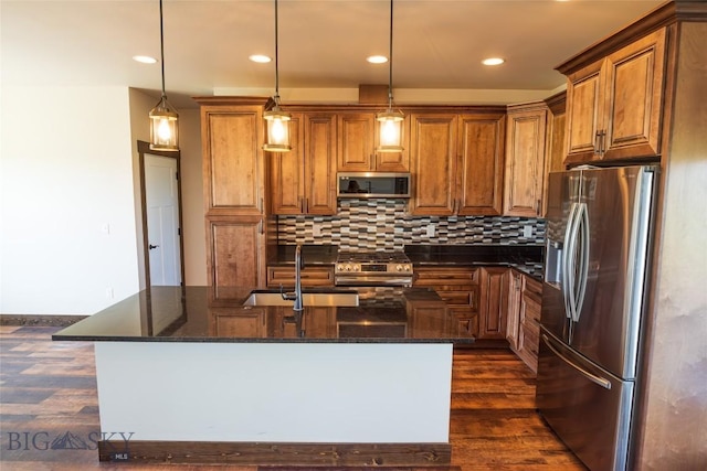 kitchen featuring stainless steel appliances, dark wood-type flooring, a sink, brown cabinetry, and recessed lighting