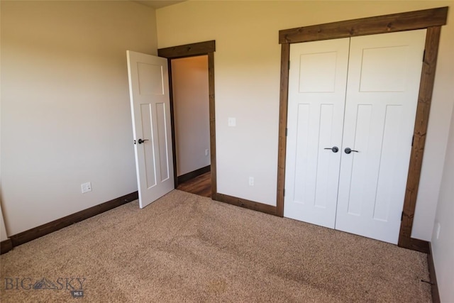 unfurnished bedroom with carpet flooring, baseboards, and a closet