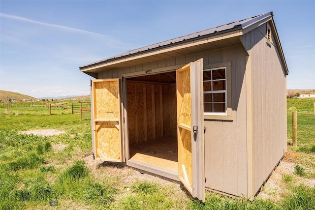view of shed featuring fence and a view of countryside