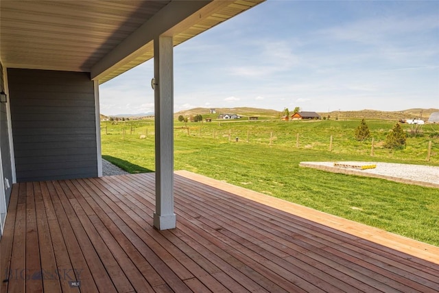 wooden deck featuring a view of rural / pastoral area and a lawn