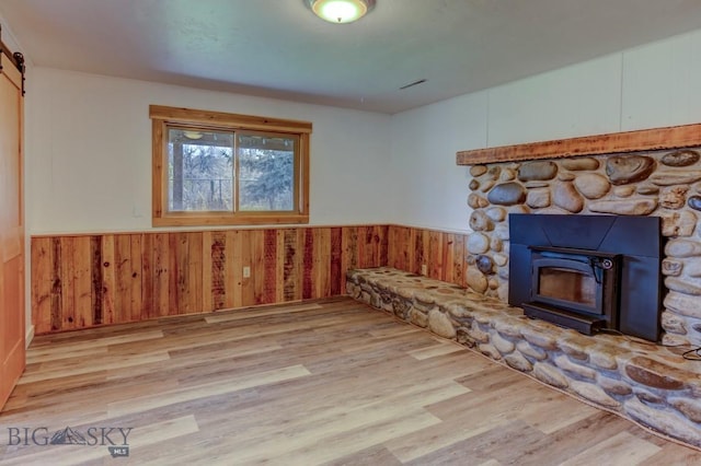 1816 S Rouse Unit 1 & 2, Bozeman, MT 59715 - unfurnished living room with wood finished floors, a wainscoted wall, wooden walls, and a barn door