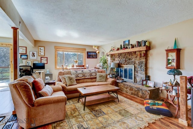 1816 S Rouse, Bozeman, MT 59715 - living room featuring wood finished floors, a textured ceiling, and a stone fireplace