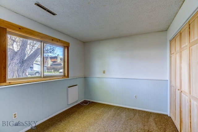 1816 S Rouse, Bozeman, MT 59715 - unfurnished bedroom with a textured ceiling, radiator, carpet, wainscoting, and a closet