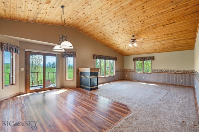 unfurnished living room featuring a wainscoted wall, vaulted ceiling, wood ceiling, ceiling fan, and wood finished floors