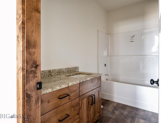 full bath with wood finished floors, vanity, and  shower combination