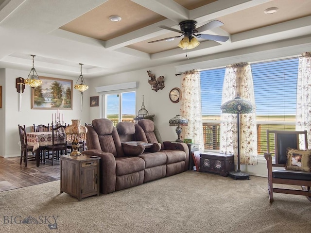 living area featuring coffered ceiling, a ceiling fan, carpet floors, and beam ceiling