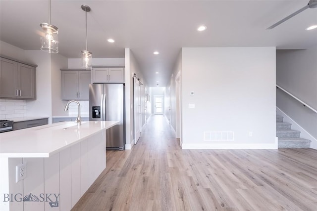 440 Meriwether Ave, Bozeman, MT 59718 - kitchen featuring stainless steel fridge, gray cabinets, a sink, light wood-style flooring, and light countertops