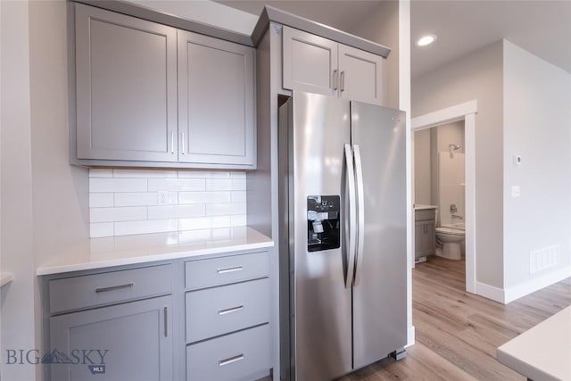 440 Meriwether Ave, Bozeman, MT 59718 - kitchen with stainless steel fridge, gray cabinets, decorative backsplash, light wood-style floors, and light countertops