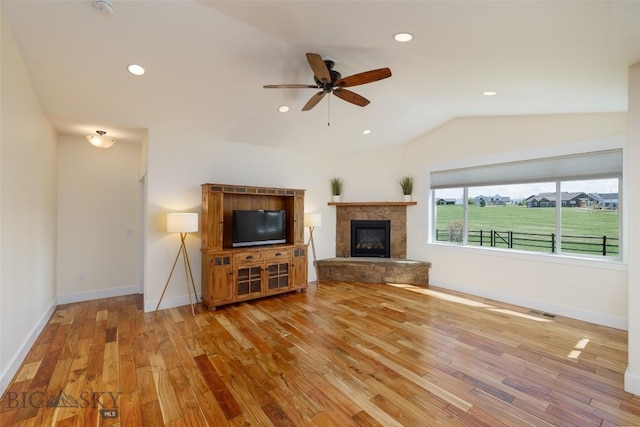 342 Parklands Trl, Bozeman, MT 59718 - unfurnished living room featuring wood finished floors, lofted ceiling, ceiling fan, a glass covered fireplace, and baseboards