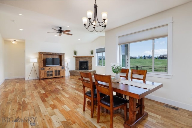 342 Parklands Trl, Bozeman, MT 59718 - dining area featuring light wood finished floors, baseboards, a chandelier, a fireplace with raised hearth, and recessed lighting