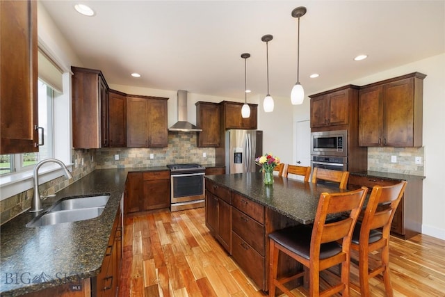 342 Parklands Trl, Bozeman, MT 59718 - kitchen with appliances with stainless steel finishes, wall chimney range hood, a sink, light wood-style floors, and tasteful backsplash