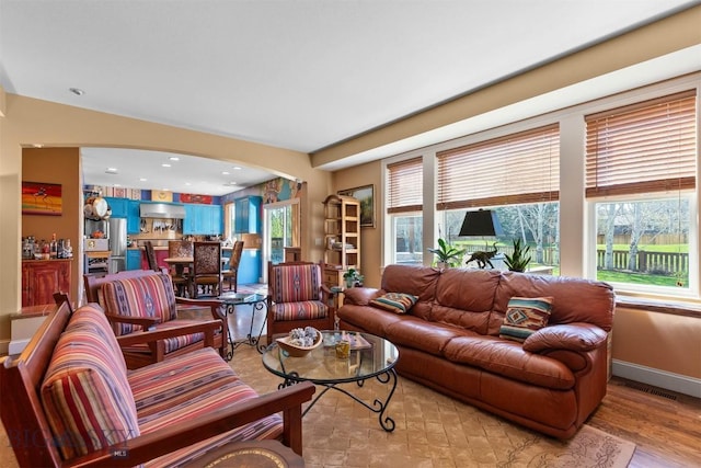 living room with arched walkways and baseboards