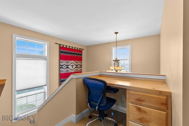 office featuring healthy amount of natural light, baseboards, and built in study area
