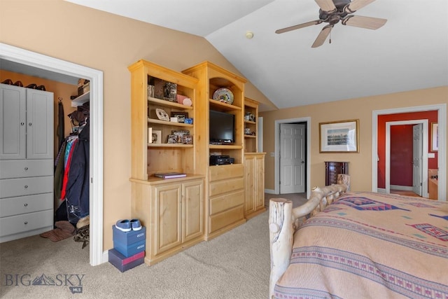 bedroom with vaulted ceiling, light colored carpet, a spacious closet, a closet, and a ceiling fan