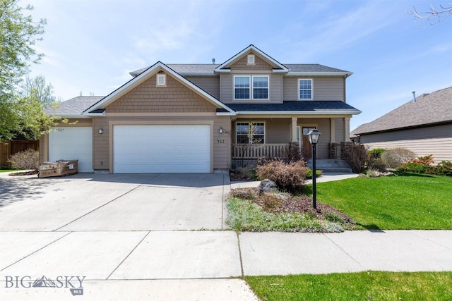view of front of home with covered porch, a front yard, a garage, and driveway