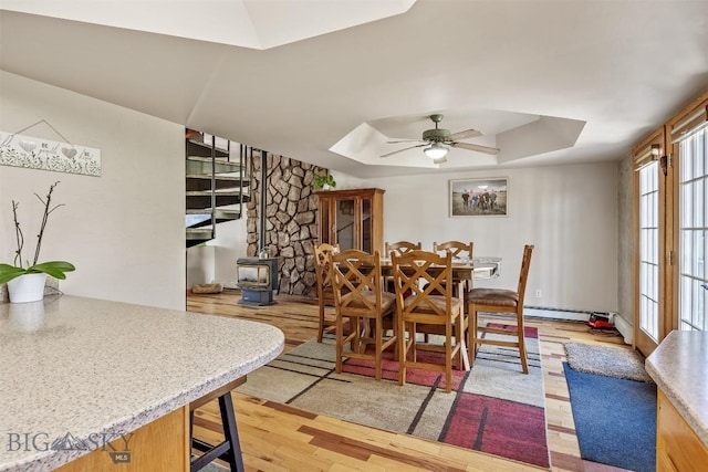 517 W Daly, Walkerville, MT 59701 - dining room featuring a wood stove, a raised ceiling, ceiling fan, light wood-style floors, and a skylight