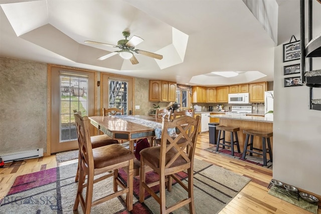 517 W Daly, Walkerville, MT 59701 - dining area featuring light wood finished floors, baseboard heating, ceiling fan, a skylight, and a tray ceiling