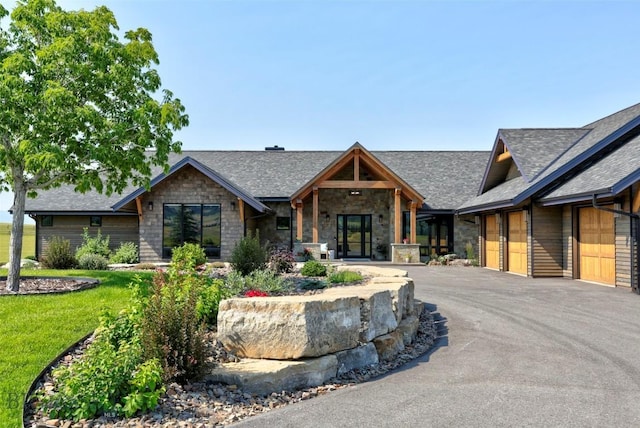 419 Upper Autumn Ridge Rd, Bozeman, MT 59715 - view of front of home featuring stone siding, a shingled roof, driveway, and a front lawn