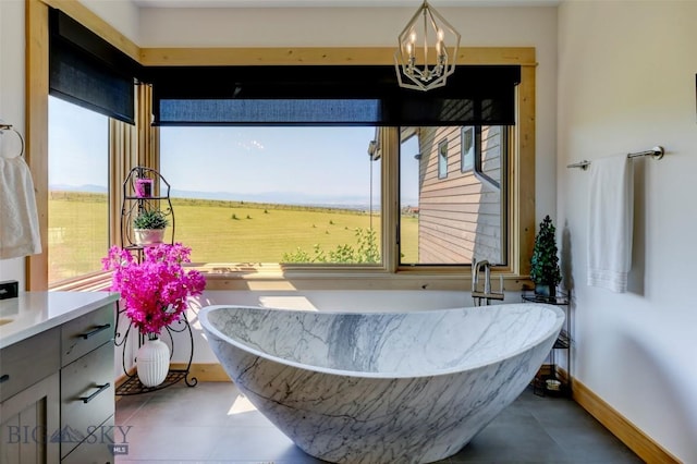 419 Upper Autumn Ridge Rd, Bozeman, MT 59715 - bathroom featuring a soaking tub, baseboards, a chandelier, and vanity