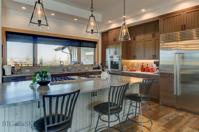 419 Upper Autumn Ridge Rd, Bozeman, MT 59715 - kitchen with stainless steel built in refrigerator, recessed lighting, wood finished floors, pendant lighting, and a breakfast bar