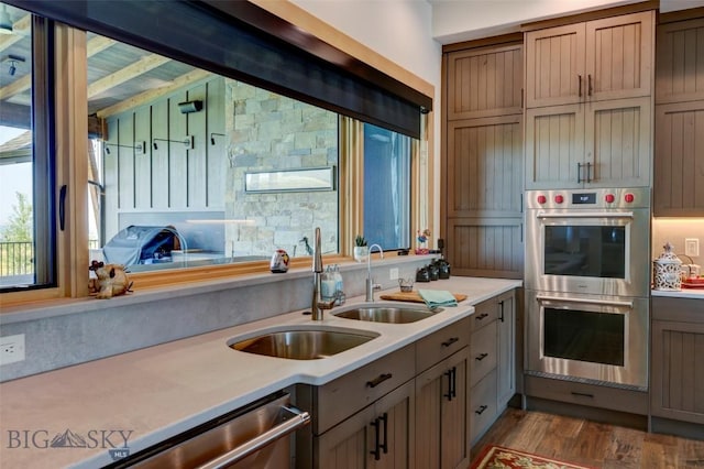 419 Upper Autumn Ridge Rd, Bozeman, MT 59715 - kitchen with stainless steel appliances, light countertops, wood finished floors, beamed ceiling, and a sink