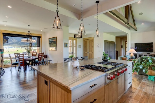 419 Upper Autumn Ridge Rd, Bozeman, MT 59715 - kitchen featuring stainless steel gas cooktop, light wood finished floors, a chandelier, a center island, and hanging light fixtures