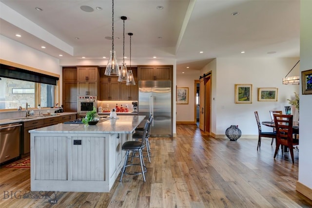 419 Upper Autumn Ridge Rd, Bozeman, MT 59715 - kitchen featuring appliances with stainless steel finishes, a large island, a breakfast bar area, recessed lighting, and brown cabinetry