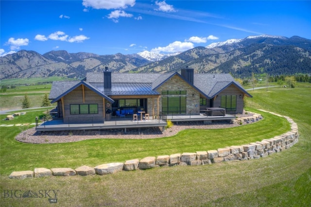 419 Upper Autumn Ridge Rd, Bozeman, MT 59715 - rear view of property with a chimney, a standing seam roof, a mountain view, stone siding, and a lawn