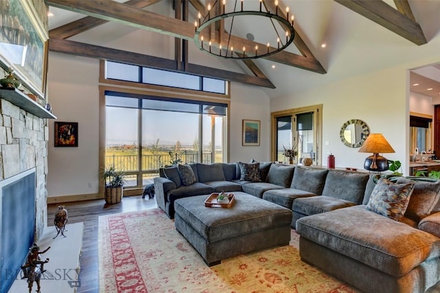 419 Upper Autumn Ridge Rd, Bozeman, MT 59715 - living room with high vaulted ceiling, beamed ceiling, light wood-style flooring, a stone fireplace, and a chandelier