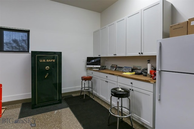 419 Upper Autumn Ridge Rd, Bozeman, MT 59715 - kitchen with freestanding refrigerator, baseboards, and white cabinetry