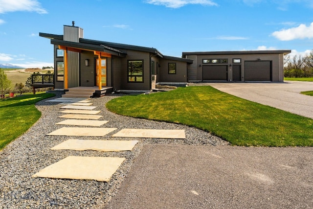 20 Prairie Falcon Ln, Belgrade, MT 59714 - view of front of home with a garage, a front yard, a chimney, and driveway