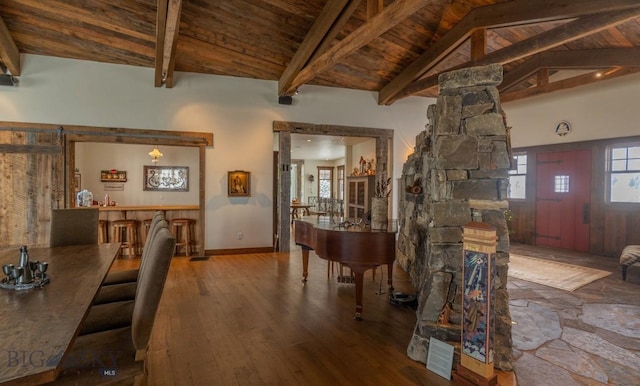 dining area featuring wood ceiling, wood finished floors, and ornate columns