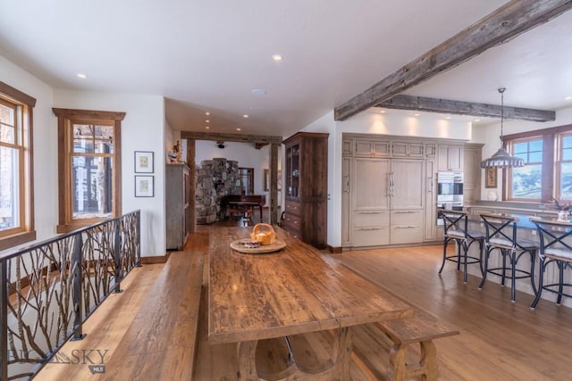 dining space featuring light wood-type flooring, recessed lighting, and beam ceiling