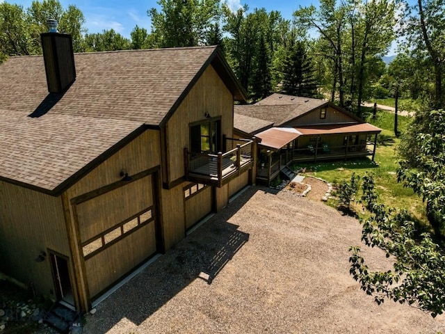view of home's exterior with a shingled roof and a chimney