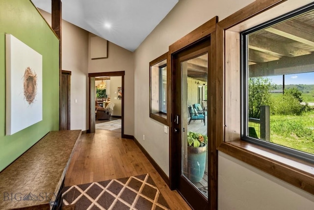 hall with dark wood finished floors, lofted ceiling, recessed lighting, and baseboards