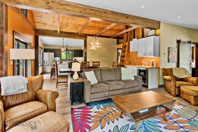living area with light wood-style floors, wine cooler, beam ceiling, a chandelier, and wood ceiling