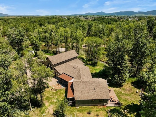 view of subject property featuring a forest and mountains