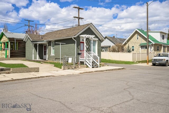 1048 S Wyoming St, Butte, MT 59701 - view of front of property with fence, roof with shingles, and brick siding