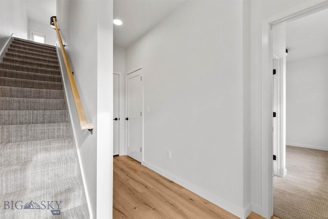 stairs featuring wood finished floors, baseboards, and recessed lighting