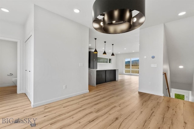 unfurnished living room featuring light wood-style floors, baseboards, and recessed lighting