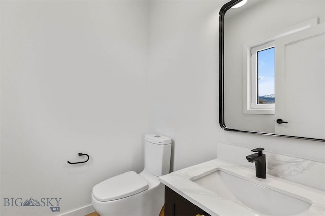 half bath featuring toilet and vanity