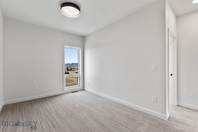 carpeted empty room with baseboards