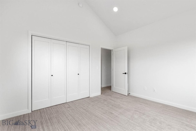 unfurnished bedroom featuring carpet flooring, high vaulted ceiling, a closet, recessed lighting, and baseboards
