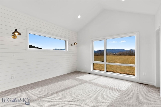 unfurnished room with carpet flooring, vaulted ceiling, a mountain view, and recessed lighting