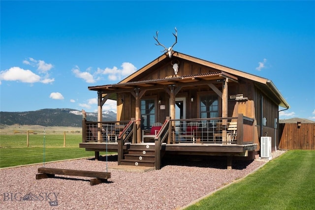 view of front of house with cooling unit and a deck with mountain view