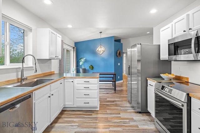 285 Hereford Dr, Belgrade, MT 59714 - kitchen with appliances with stainless steel finishes, a sink, light wood finished floors, white cabinets, and recessed lighting