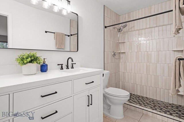 285 Hereford Dr, Belgrade, MT 59714 - bathroom featuring toilet, a tile shower, vanity, and tile patterned floors