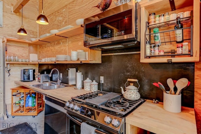 1007 E Geyser, Livingston, MT 59047 - kitchen with appliances with stainless steel finishes, a sink, decorative backsplash, butcher block counters, and hanging light fixtures