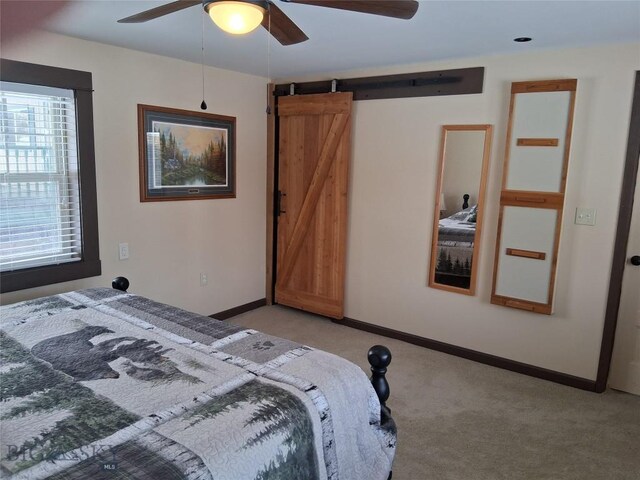 967 Mt Highway 2 W, Whitehall, MT 59759 - bedroom with a barn door, light colored carpet, baseboards, and ceiling fan