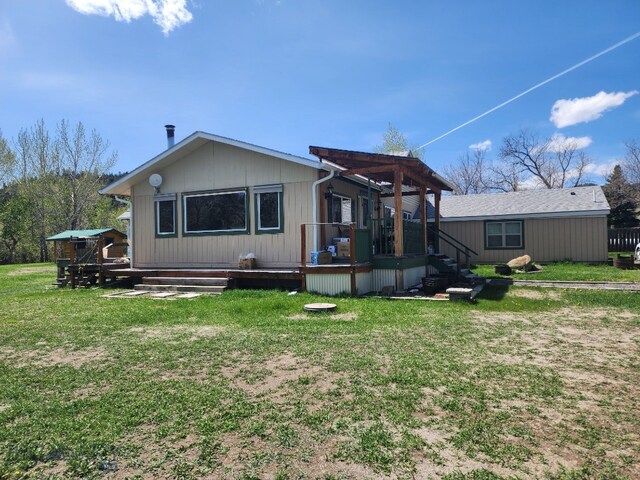 967 Mt Highway 2 W, Whitehall, MT 59759 - rear view of house featuring a wooden deck and a lawn